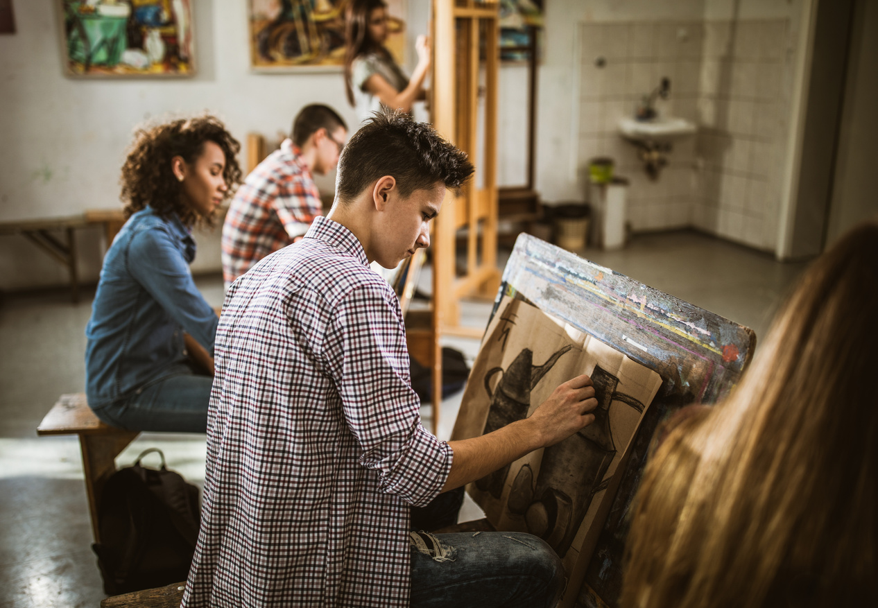 Group of art students drawing paintings at art studio.